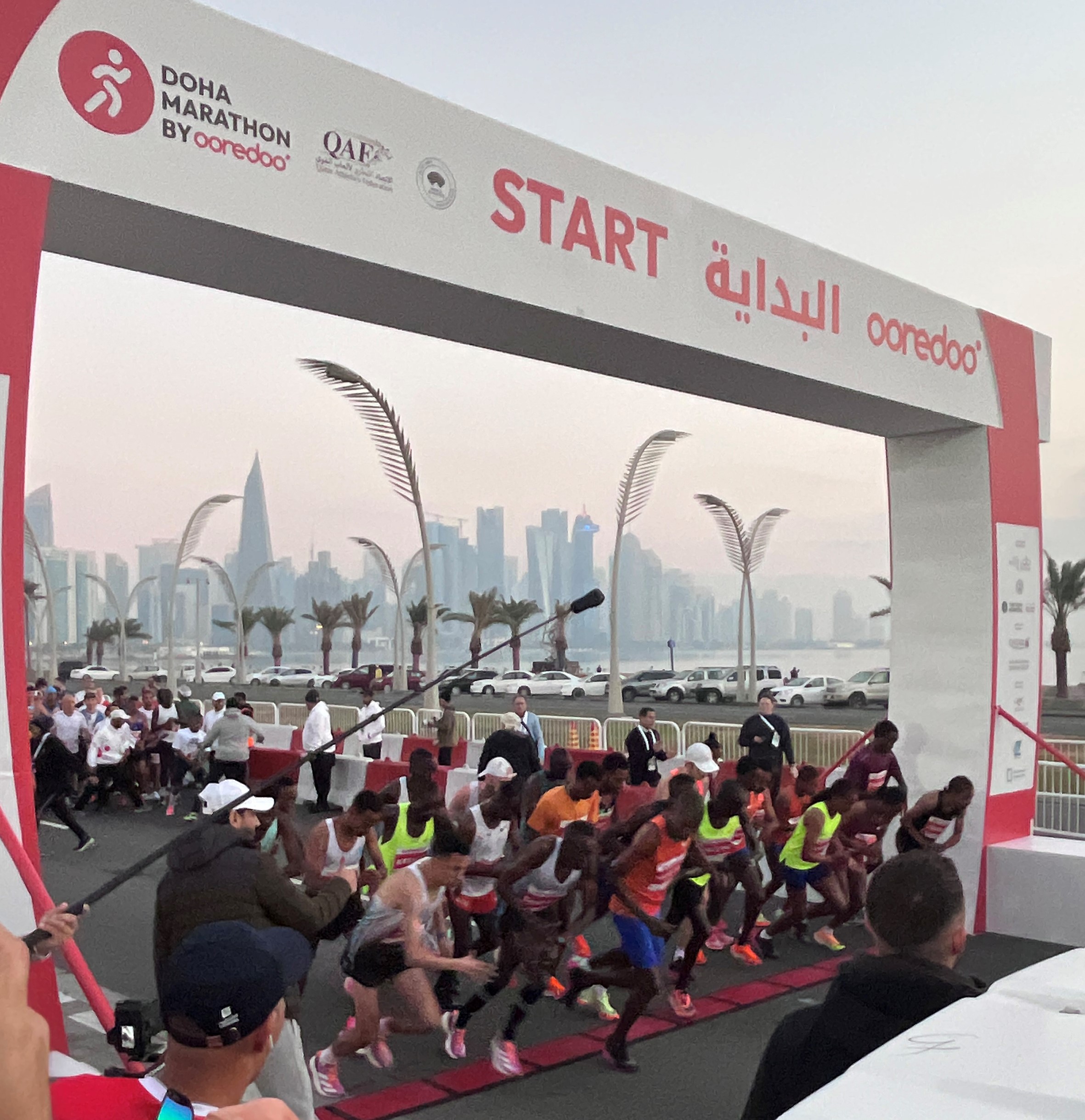 Image shows runners at the start line of a marathon race in Qatar.